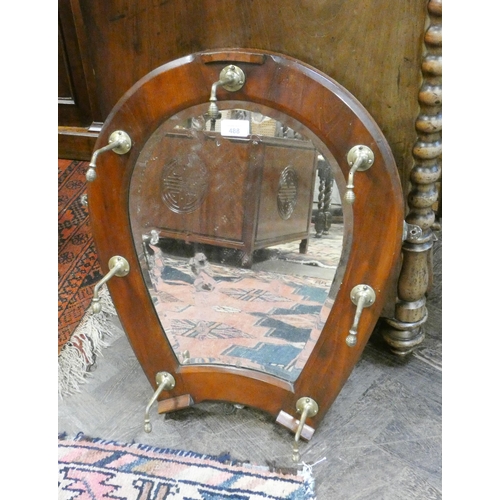 488 - An 1930's mahogany framed horseshoe shaped hall mirror with brass hat hooks