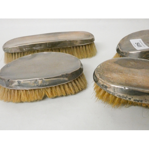 545 - A collection of four silver backed hairbrushes.