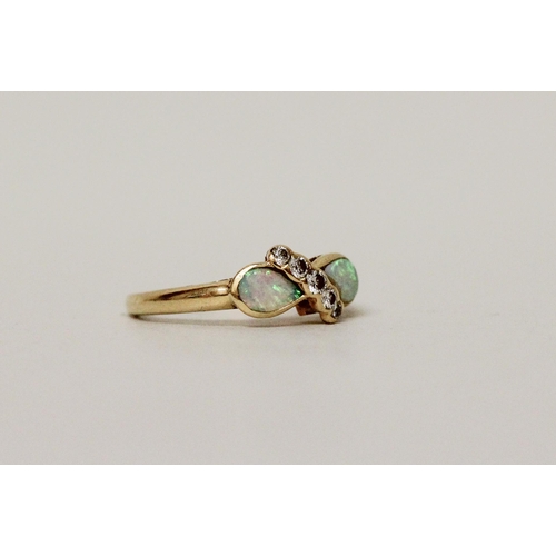 584 - An opal and diamond dress ring, set two tear drop shaped opals with a band of diamonds. 18ct yellow ... 