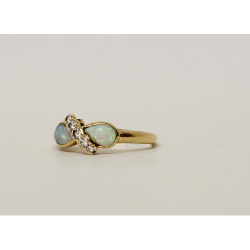 584 - An opal and diamond dress ring, set two tear drop shaped opals with a band of diamonds. 18ct yellow ... 