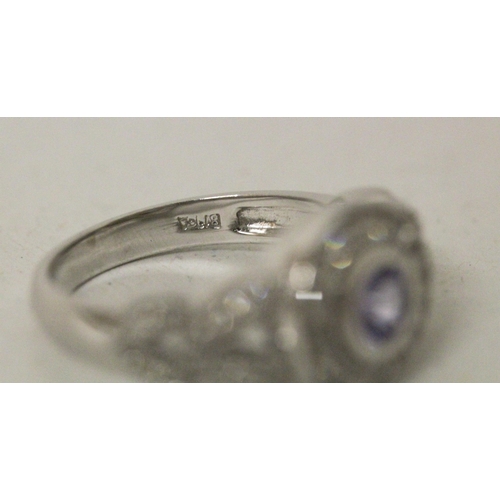 596 - A modern tanzanite and diamond dress ring, the circular tanzanite in 14K white gold collet setting w... 