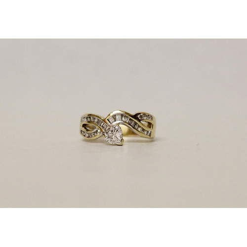 620 - A modern diamond dress ring, heart shaped diamond claw set to a channel set princess cut diamond ban... 