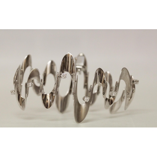 624 - A Modernist 18ct white gold and diamond set wavy design bracelet, with polished and matt sections se... 