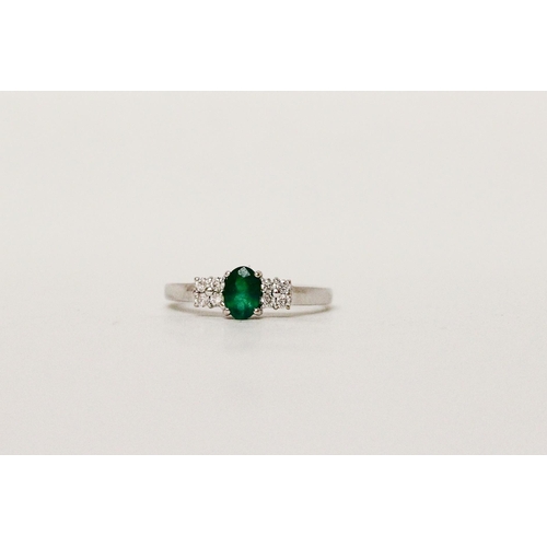 627 - An emerald and diamond ring, on hallmarked 18ct white gold band. Ring size N, 2.8g