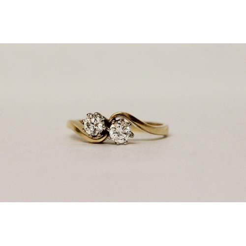 630 - A diamond two stone ring, on cross over setting, hallmarked 18ct yellow gold band. Ring size O/P, 3.... 