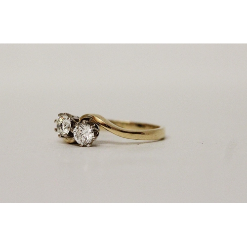 630 - A diamond two stone ring, on cross over setting, hallmarked 18ct yellow gold band. Ring size O/P, 3.... 