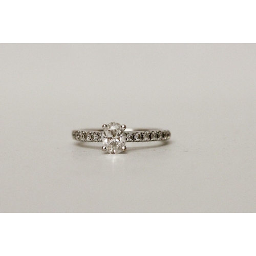 648 - A modern diamond ring, with an oval claw set diamond  to diamond shoulders, Hallmarked 18ct white go... 