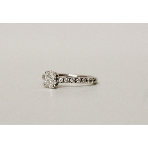 648 - A modern diamond ring, with an oval claw set diamond  to diamond shoulders, Hallmarked 18ct white go... 