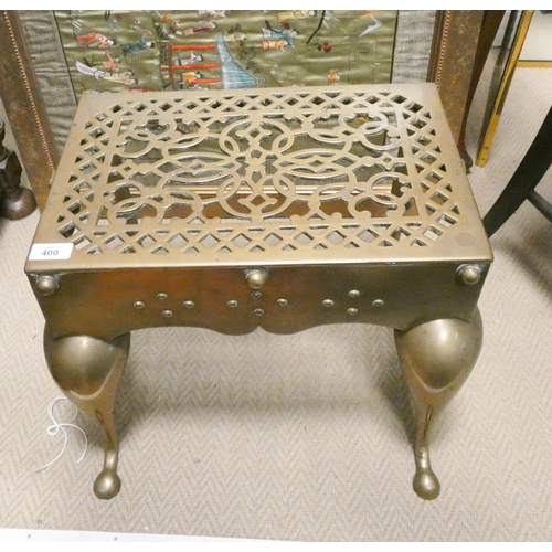 400 - A large heavy brass pierced trivet on shaped legs with carrying handles, approx. 18