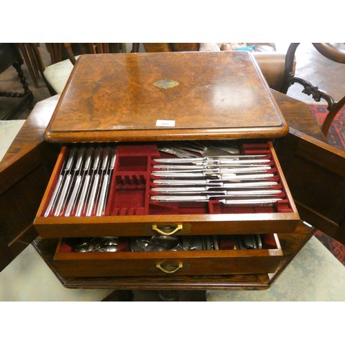 495 - Victorian walnut canteen  box, the cupboard style doors opening to three cutlery drawers, full of la... 