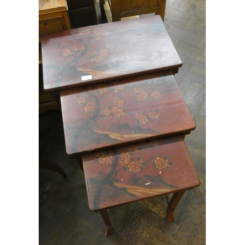 55 - A nest of Oriental red lacquered flower decorated coffee tables