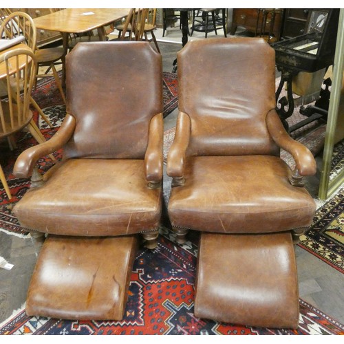 499 - A pair of antiqued brown leather library style open arm chairs and matching footstools