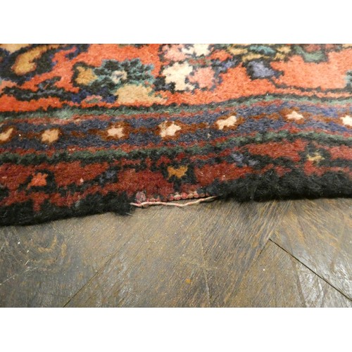 370 - A large red and figured wool pile Persian design rug 2.5m x 1.56m