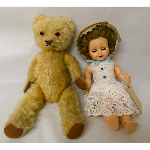 657 - A jointed Teddy bear in golden mohair with glass eyes, 50cms tall and a 1950's vintage dressed doll