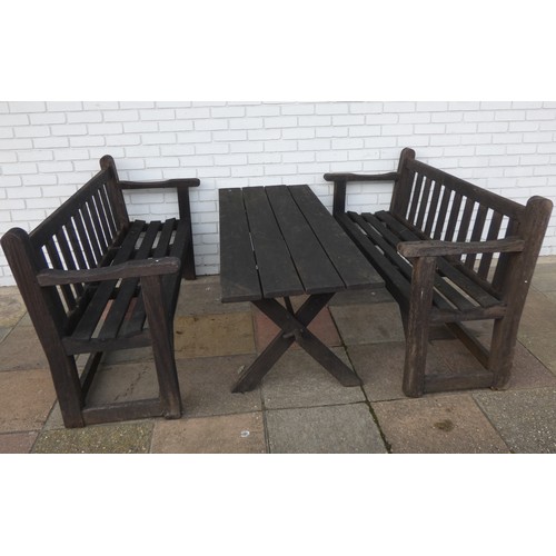 423 - A pair of three seater hardwood garden benches and a matching garden table