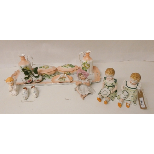 215 - A collection of Bisque Piano Babies and a vintage china dressing table set