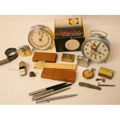 218 - Collectables to include two vintage alarm clocks, a gold plated pocket watch, some unusual lighters,... 