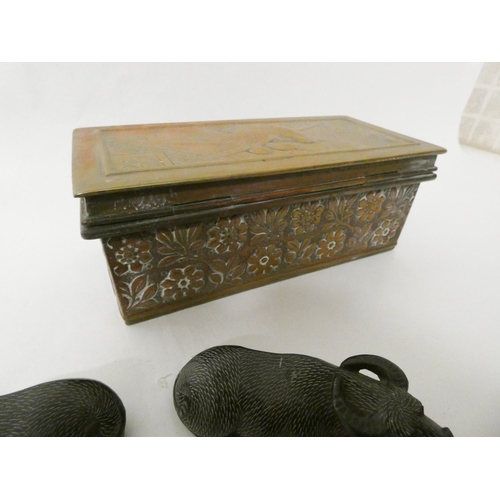 228 - An Arts and Crafts brass casket, two carved stone buffalo and a collection of commemorative crowns