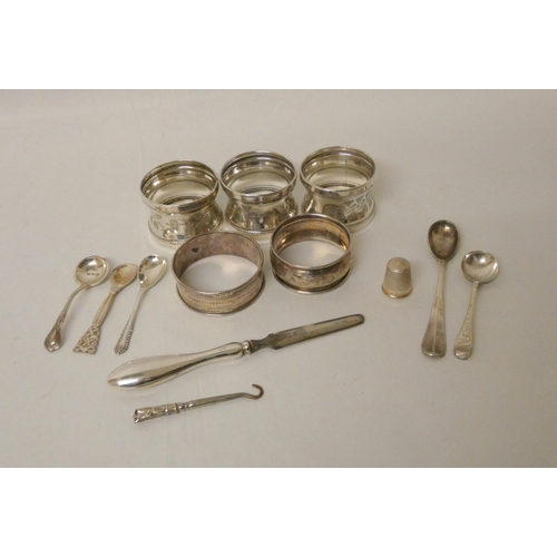 511 - A collection of five silver napkin rings of various designs, salt spoons, a thimble etc, weighable s... 