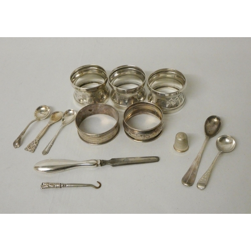 511 - A collection of five silver napkin rings of various designs, salt spoons, a thimble etc, weighable s...