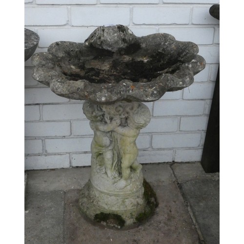 426 - A birdbath with shell top and three small children base