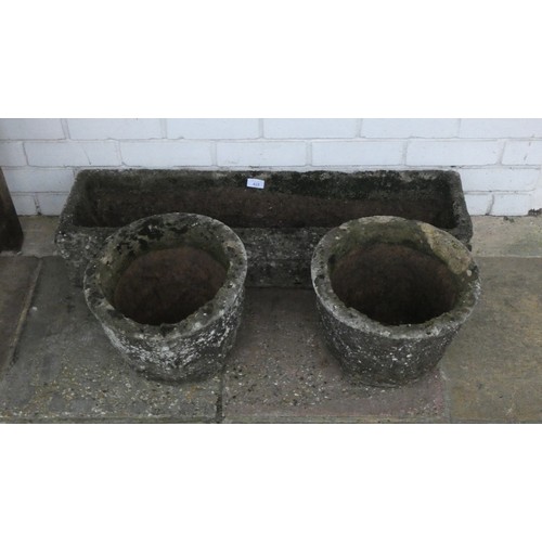 429 - A reconstituted stone trough shape garden planter and two small circular garden planters