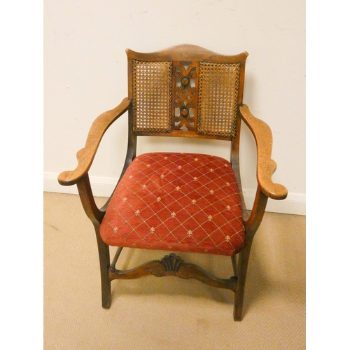 116 - A walnut elbow chair with upholstered seat and cane panel back