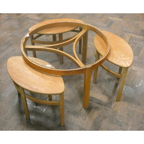 314 - A retro teak framed circular occasional table with a nest of smaller tables beneath