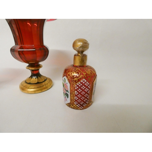 239 - A Bohemian ruby glass and gilt decorated miniature urn shaped vase together with a smaller pair of u... 