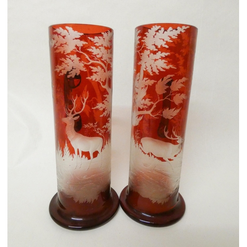 241 - A pair of Bohemian ruby glass etched flagons decorated with deer stags in a forest, each measuring 9... 