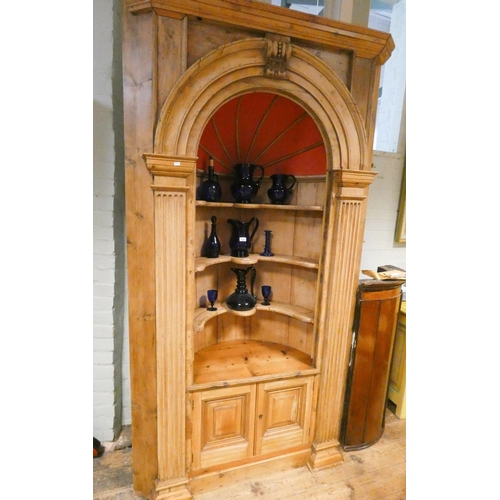 335 - An antique stripped pine concave corner cabinet with painted vaulted interior...