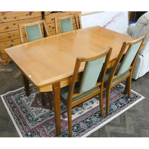 38 - An 1970's/1980's teak extending dining table with two centre leaves together with four matching chai... 