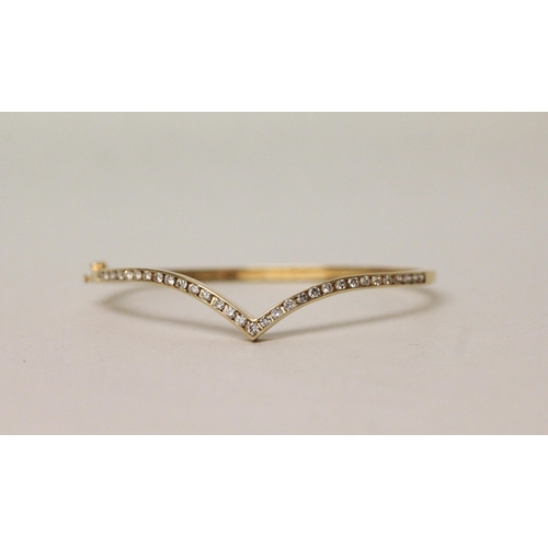 546 - A modern diamond set wishbone design bangle, in 18ct yellow gold, unmarked. Gross weight 11.7g