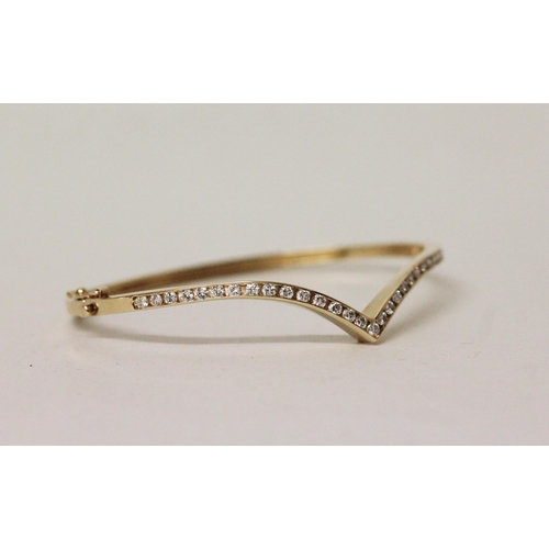 546 - A modern diamond set wishbone design bangle, in 18ct yellow gold, unmarked. Gross weight 11.7g