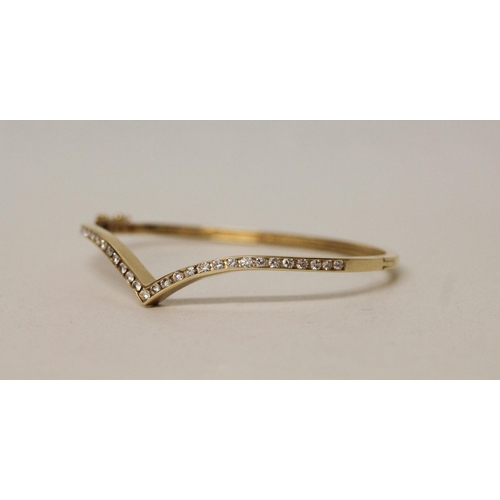 546 - A modern diamond set wishbone design bangle, in 18ct yellow gold, unmarked. Gross weight 11.7g