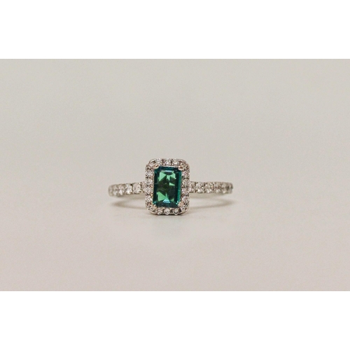 553 - A modern emerald and diamond rectangular cluster ring, platinum band with diamond shoulders. Ring si... 