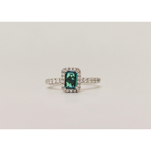 553 - A modern emerald and diamond rectangular cluster ring, platinum band with diamond shoulders. Ring si...