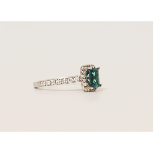 553 - A modern emerald and diamond rectangular cluster ring, platinum band with diamond shoulders. Ring si...