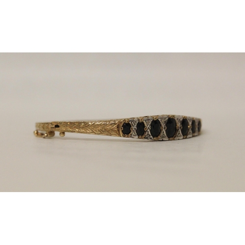 555 - A 9ct yellow gold bangle set with sapphires and diamonds in the Victorian style, gross weight 14.5 g...