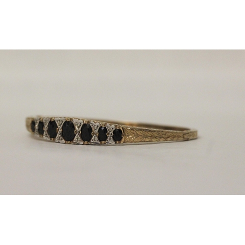 555 - A 9ct yellow gold bangle set with sapphires and diamonds in the Victorian style, gross weight 14.5 g...