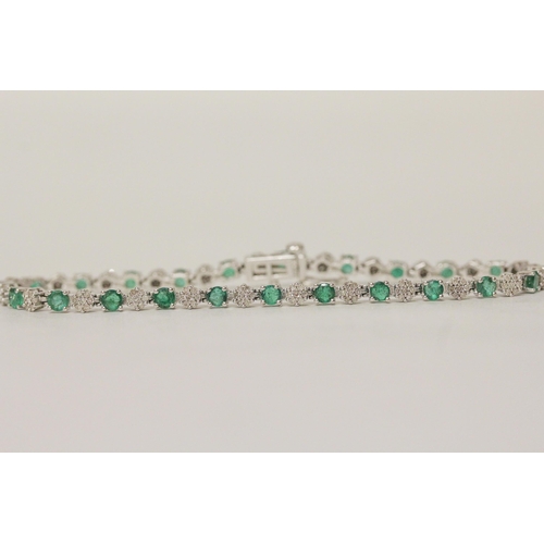 568 - An emerald and diamond line bracelet in 9ct white gold, hallmarked, 19cm long, 8.3 grams