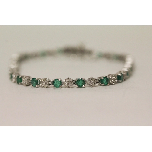 568 - An emerald and diamond line bracelet in 9ct white gold, hallmarked, 19cm long, 8.3 grams