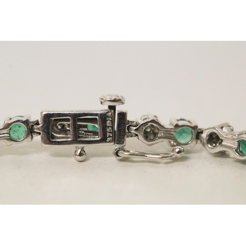 568 - An emerald and diamond line bracelet in 9ct white gold, hallmarked, 19cm long, 8.3 grams