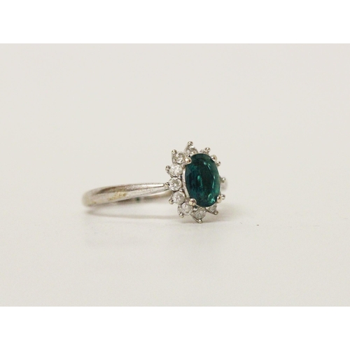 569 - A modern emerald and diamond oval cluster ring on hallmarked 9ct white gold band, ring size M, 2.2 g...