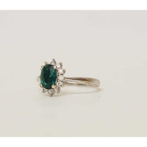 569 - A modern emerald and diamond oval cluster ring on hallmarked 9ct white gold band, ring size M, 2.2 g...