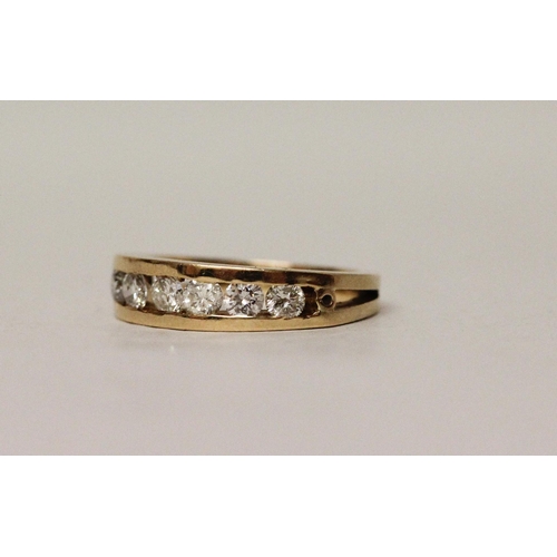 571 - A large modern 18ct yellow gold diamond half hoop eternity ring, channel set with seven brilliant cu...