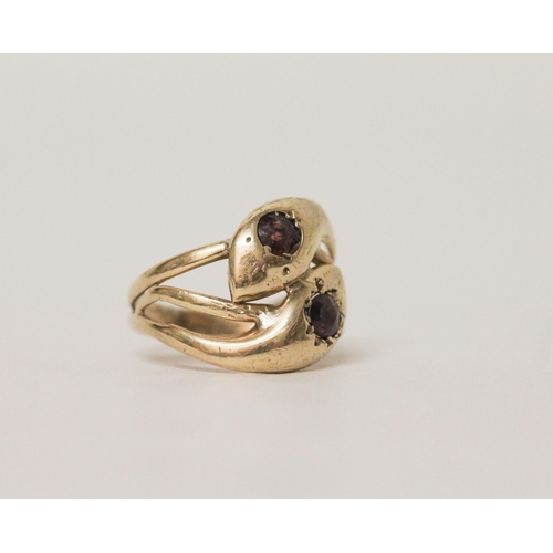 573 - A 9ct yellow gold double snake head ring set with garnets. Hallmarked, ring size S. 4.1 grams