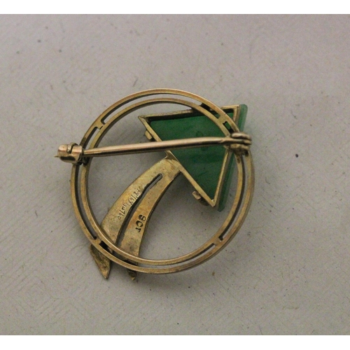 577 - A stylish 9ct yellow gold circular brooch, decorated with an arrow, the arrow head of carved jade, 3... 