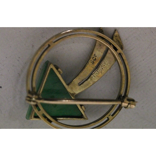 577 - A stylish 9ct yellow gold circular brooch, decorated with an arrow, the arrow head of carved jade, 3... 