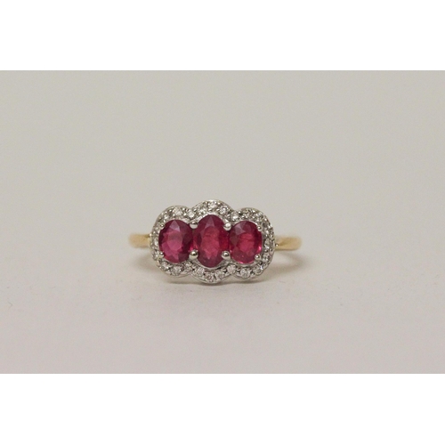 583 - A three stone ruby and diamond triple cluster ring on 18ct yellow gold band, ring size K, 4.1 grams